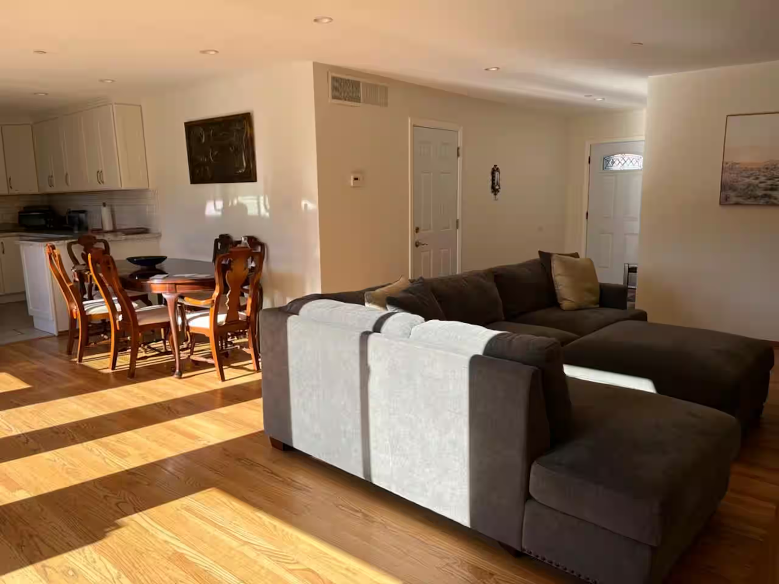 Dining room with a wood table seating six, open to the kitchen and living room