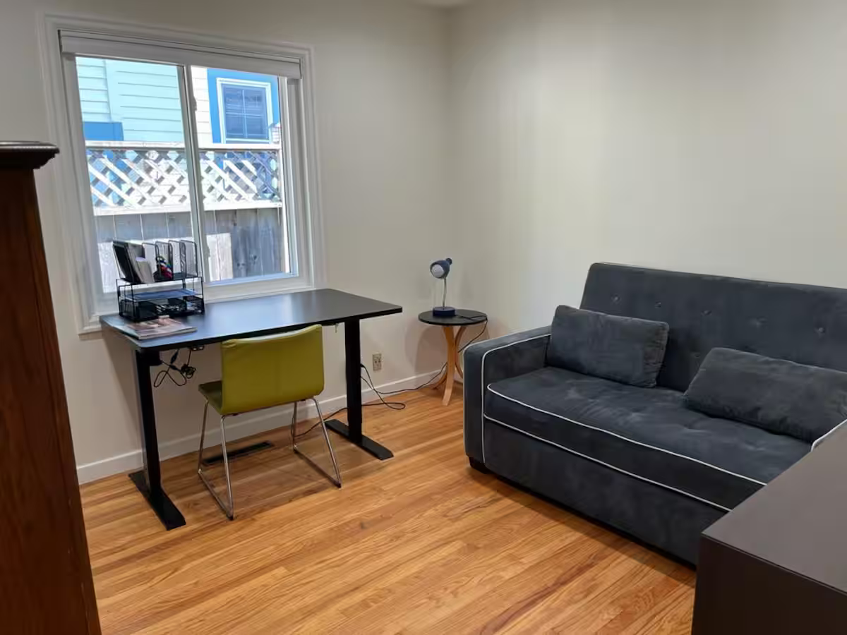 Flex room with a desk, office chair, and pull-out sofa bed