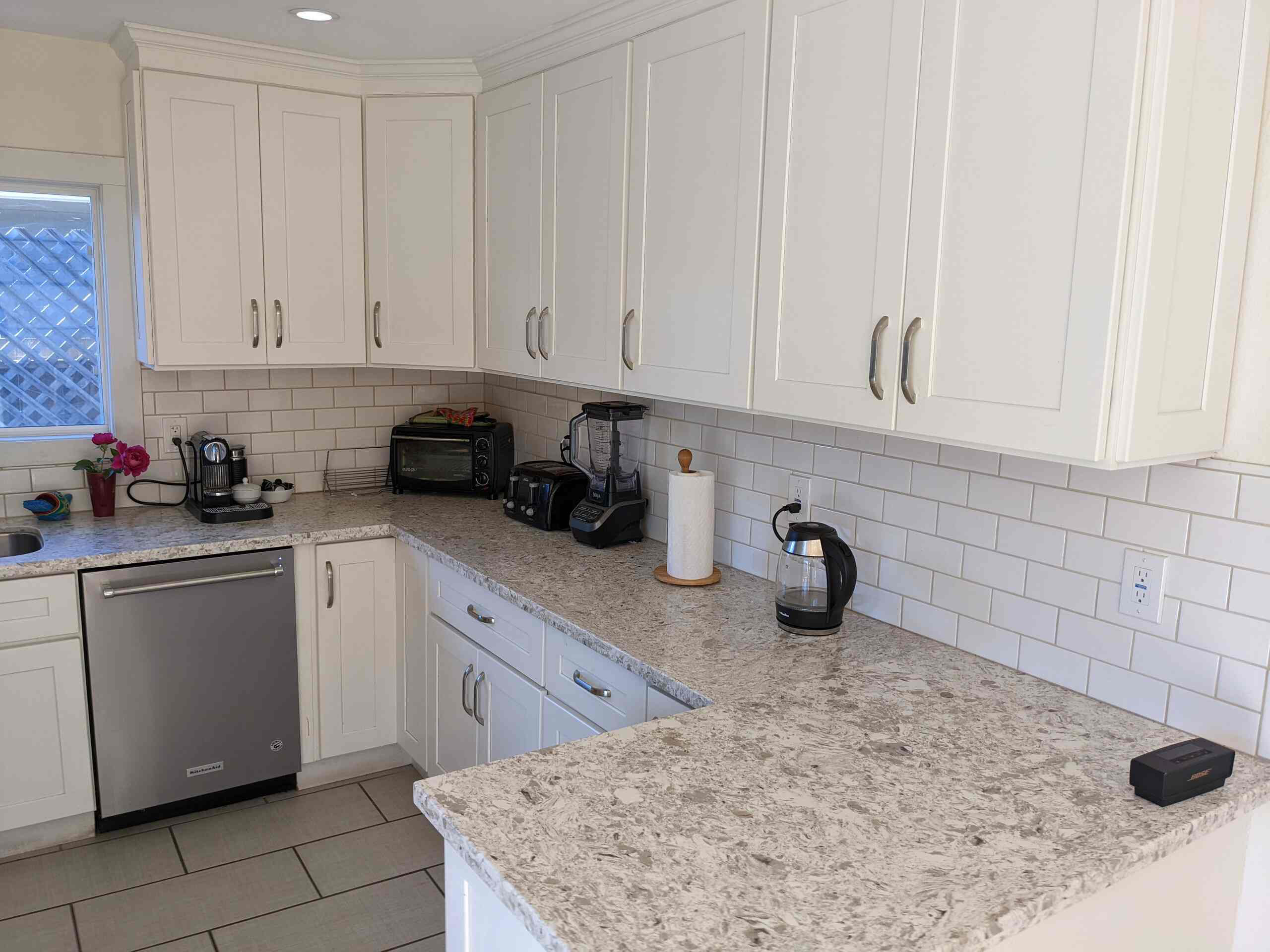 Kitchen counter with coffee maker, kettle, toaster, blender, and quartz countertops